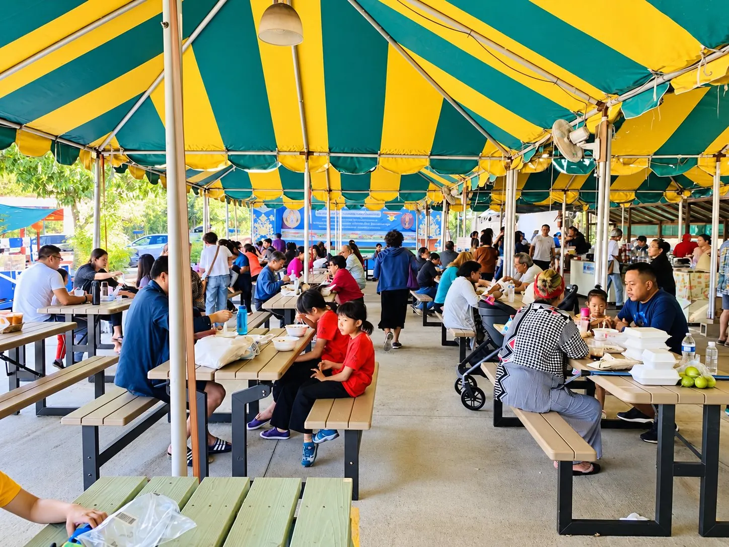 People eating under the tent at the Sunday market